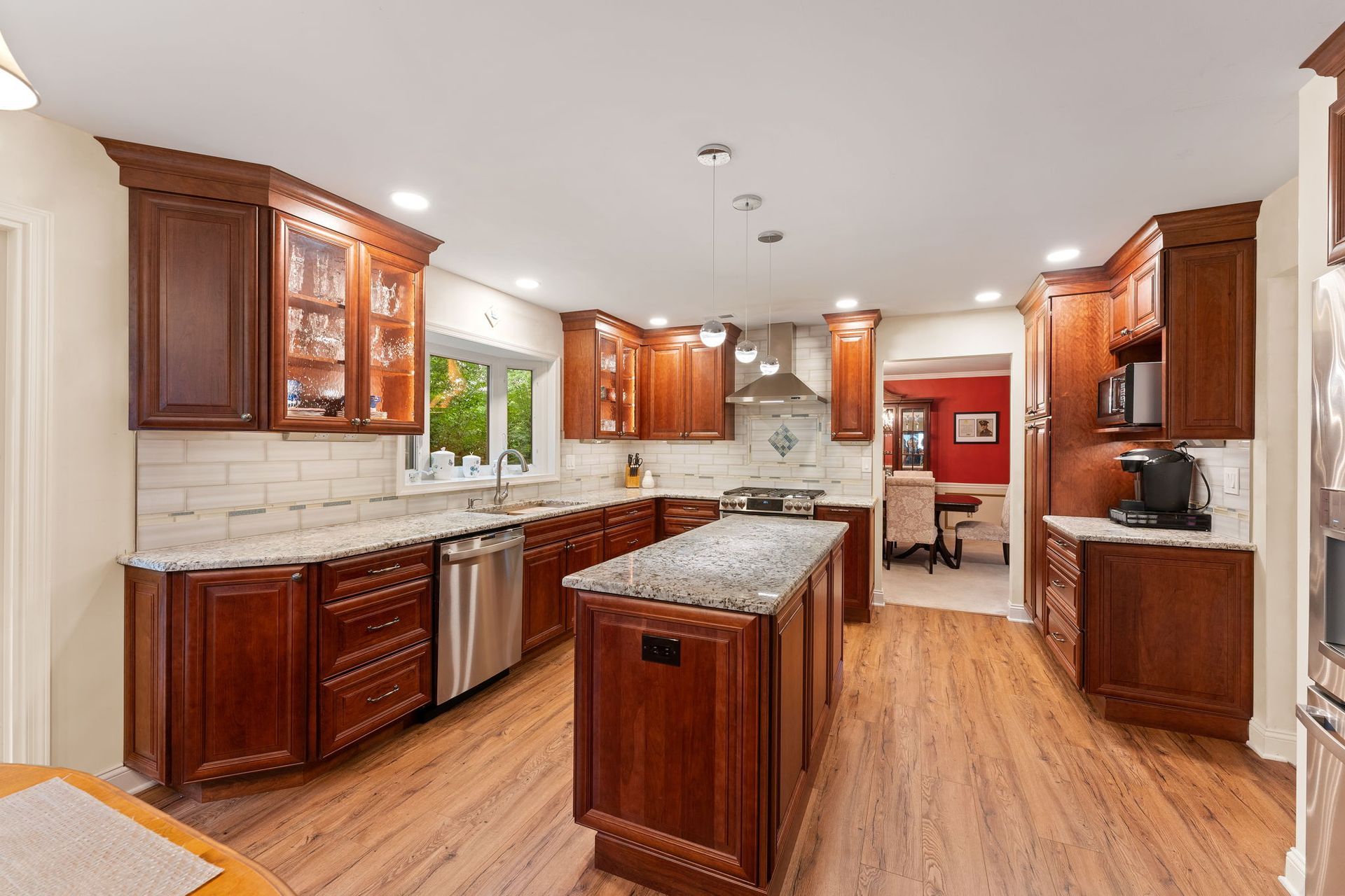 Spacious kitchen with cherry wood cabinets, granite island, stainless appliances, and wood floors  In Bucks County PA