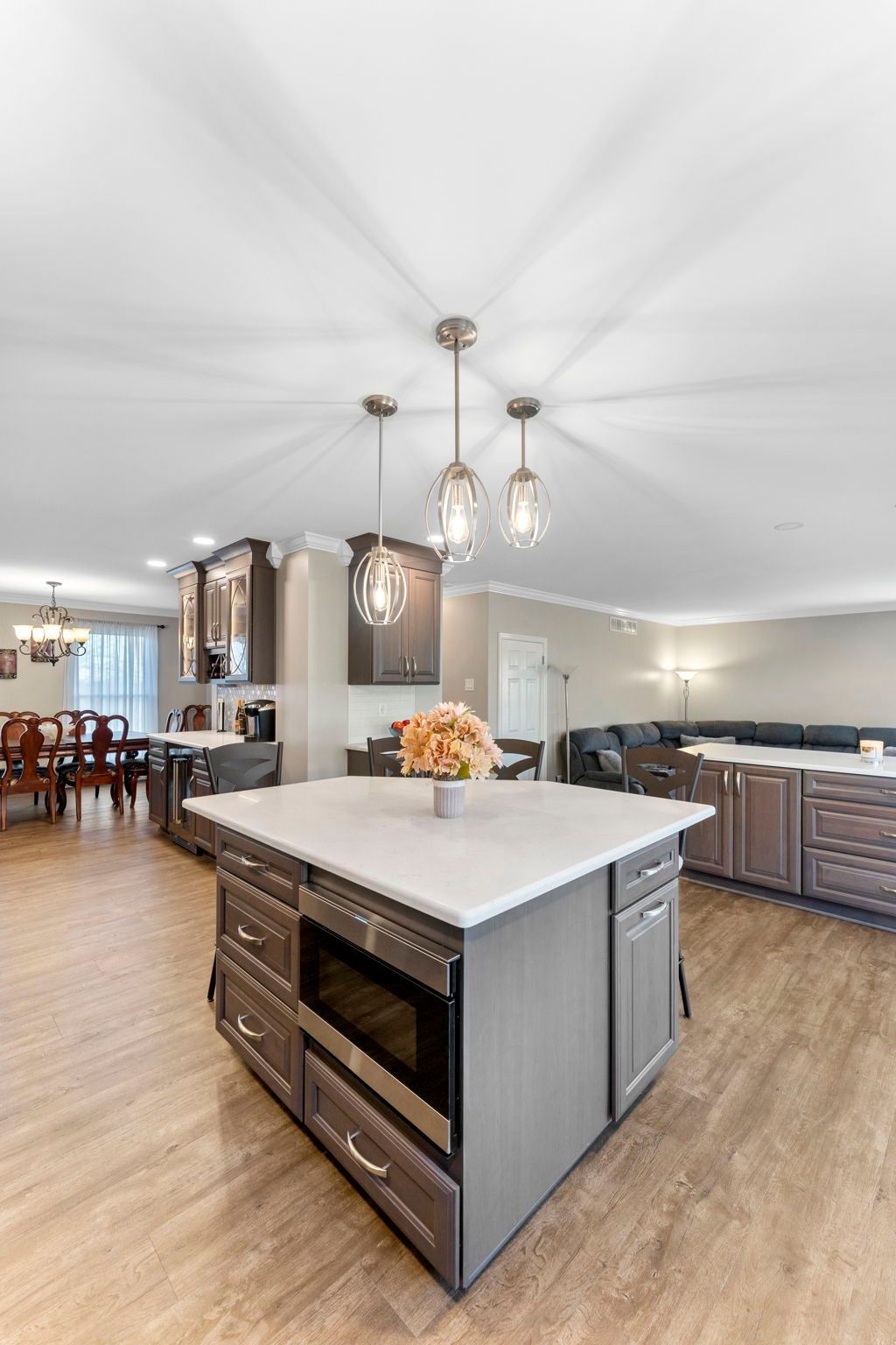 Spacious modern kitchen with marble island, hanging lights, and open dining area In Bucks Country PA