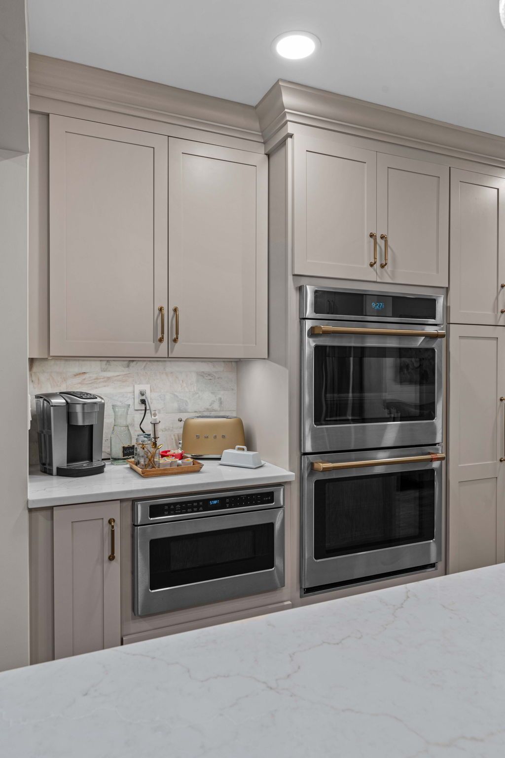 Modern kitchen with beige cabinets, built-in stainless ovens, and a white countertop in Bucks County PA