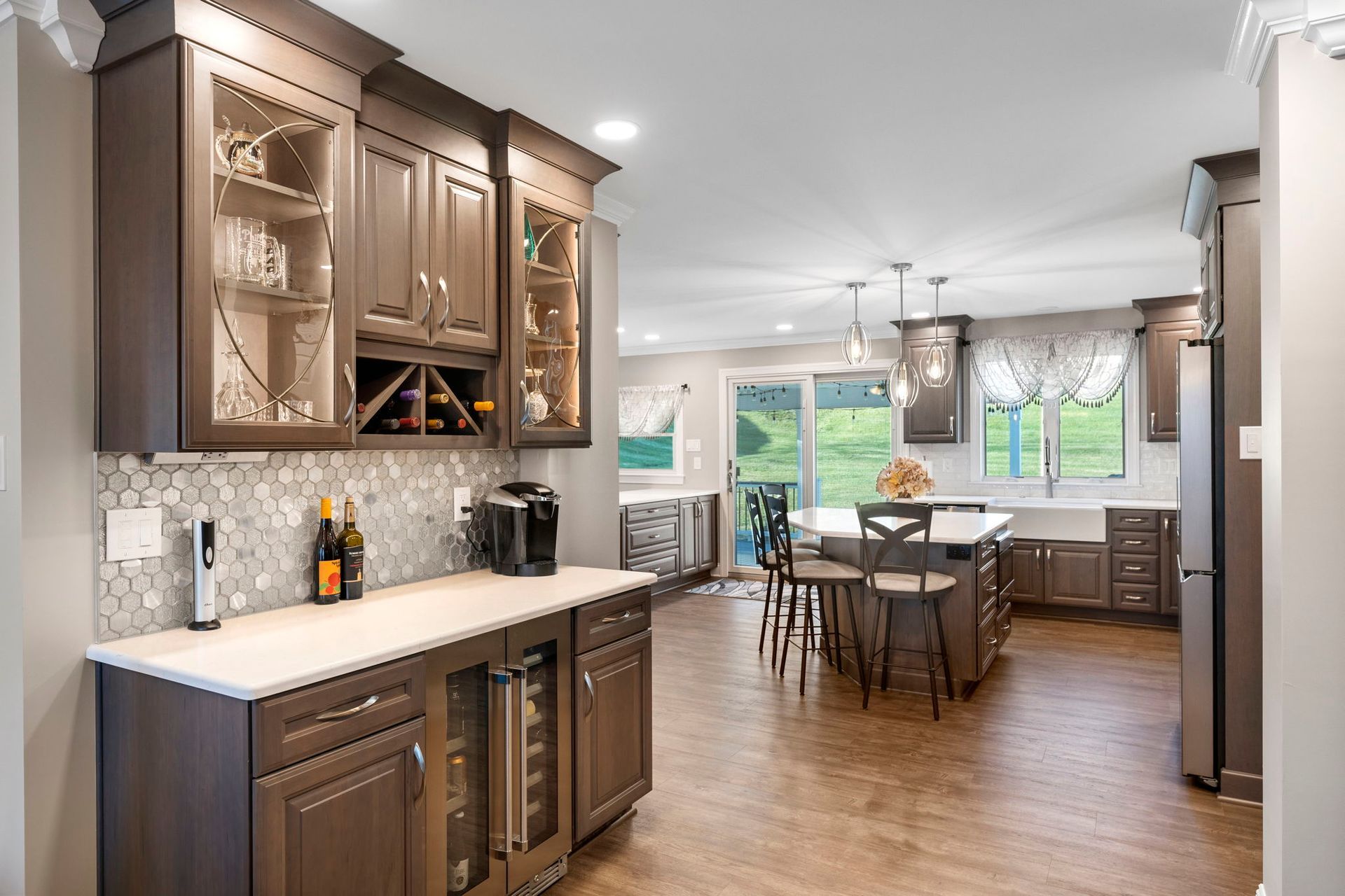 Modern kitchen with dark wood cabinets, white countertops, and a dining area by bright windows In Bucks Country PA