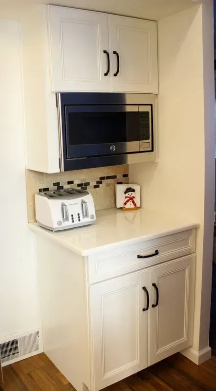 Built-in kitchen cabinets with a microwave, toaster, and countertop in a small nook In Bucks County PA
