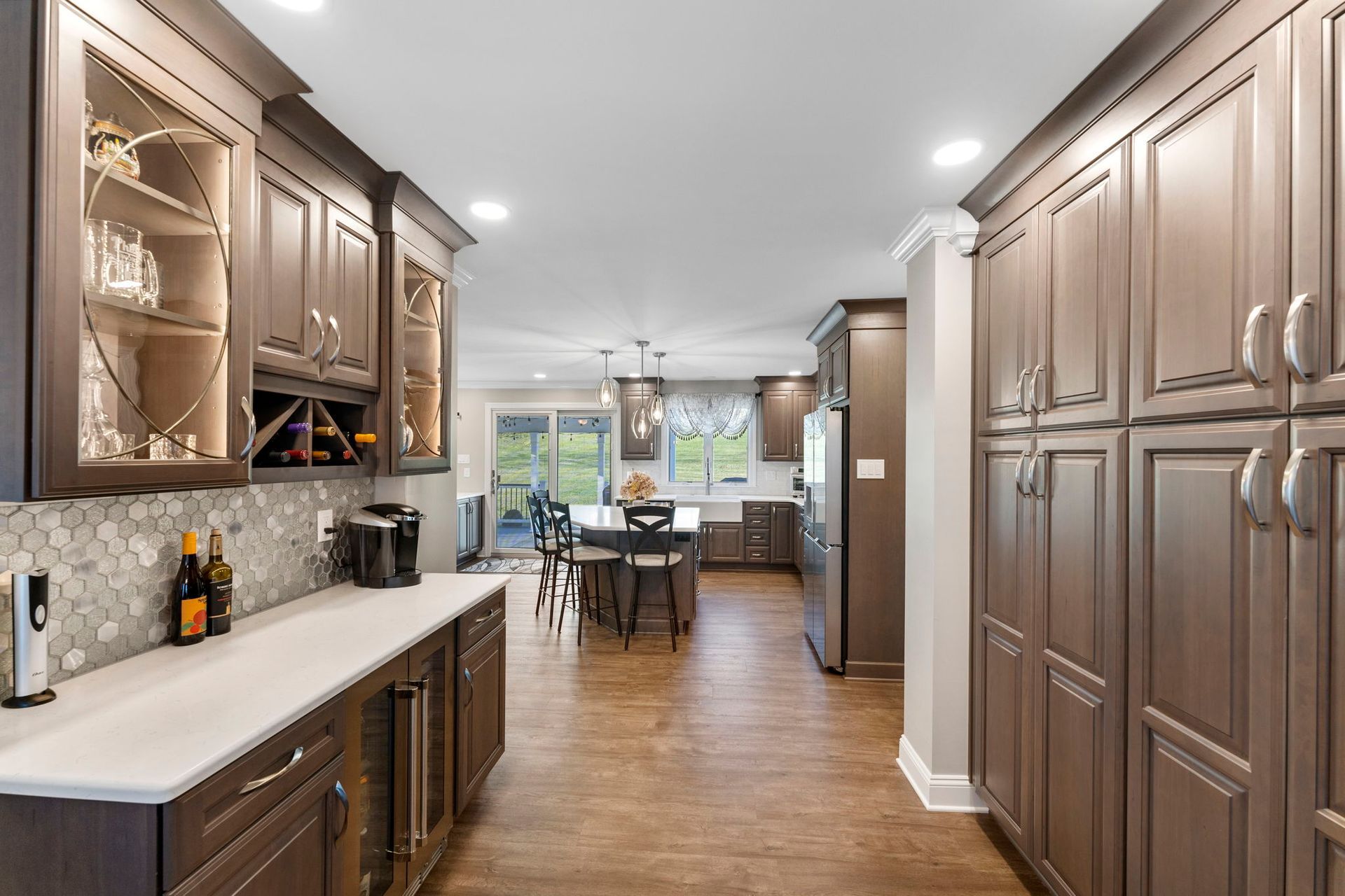 Modern kitchen with dark wood cabinets, white countertops, and hardwood floors looking into a dining area In Bucks Country PA