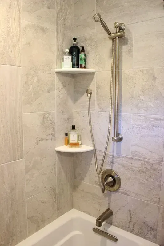 Bathroom shower with handheld sprayer and two corner shelves holding toiletries  In Bucks County PA
