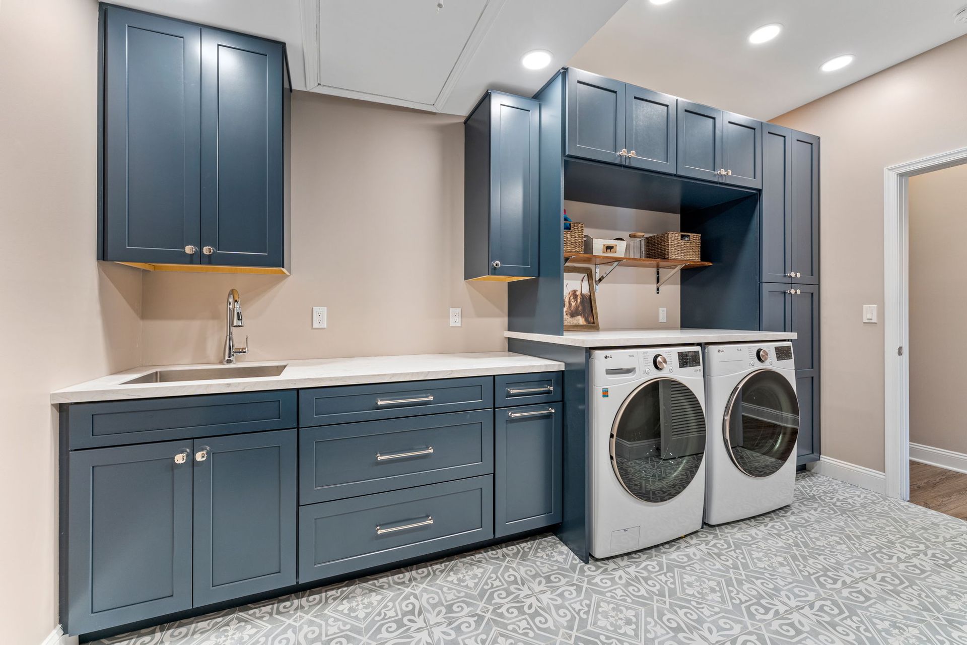 Laundry room with blue cabinets, countertop, and two front-loading washers and dryers In Bucks County PA