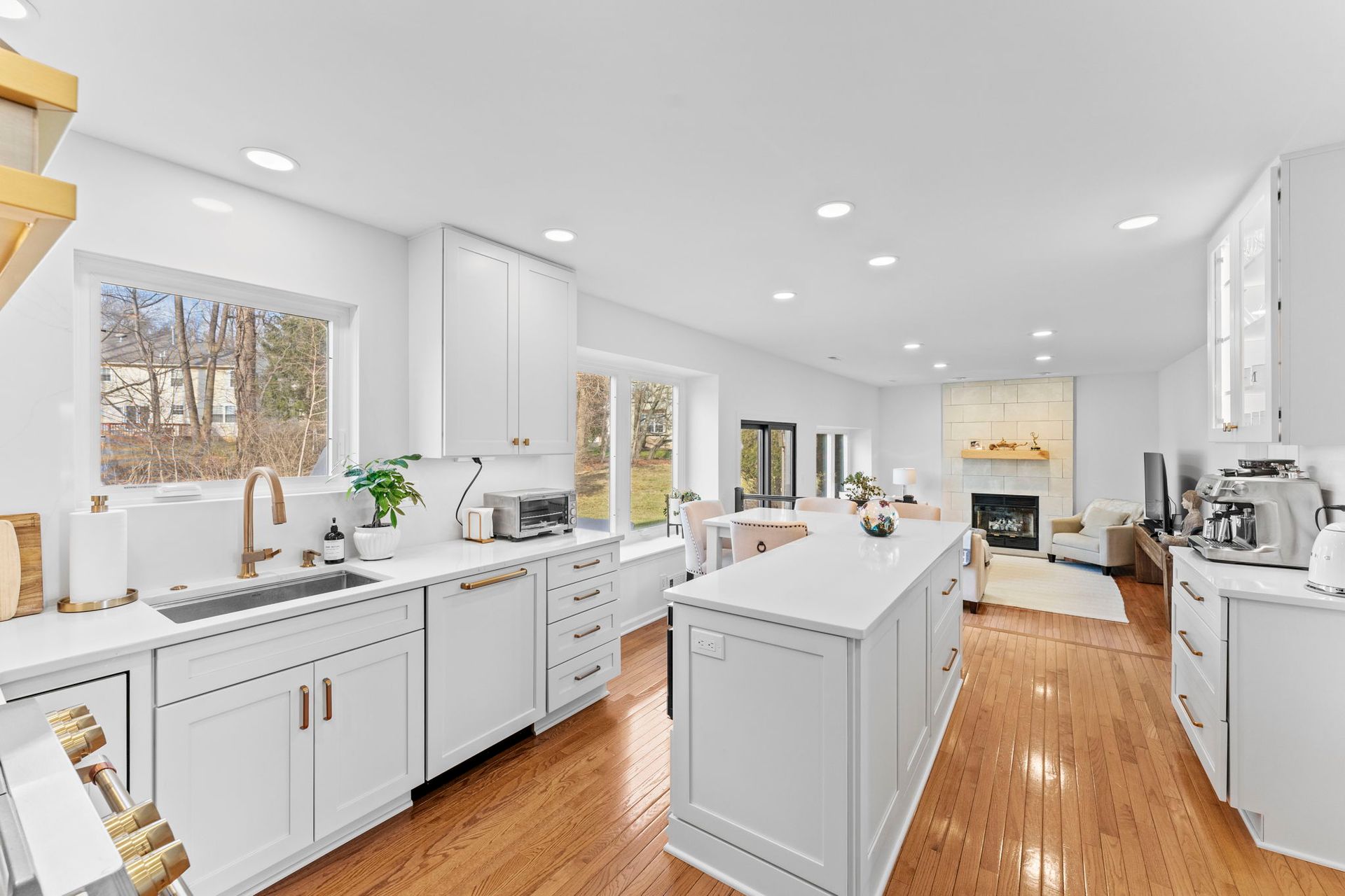 Bright white modern kitchen with island, hardwood floors, and large windows In Bucks Country PA