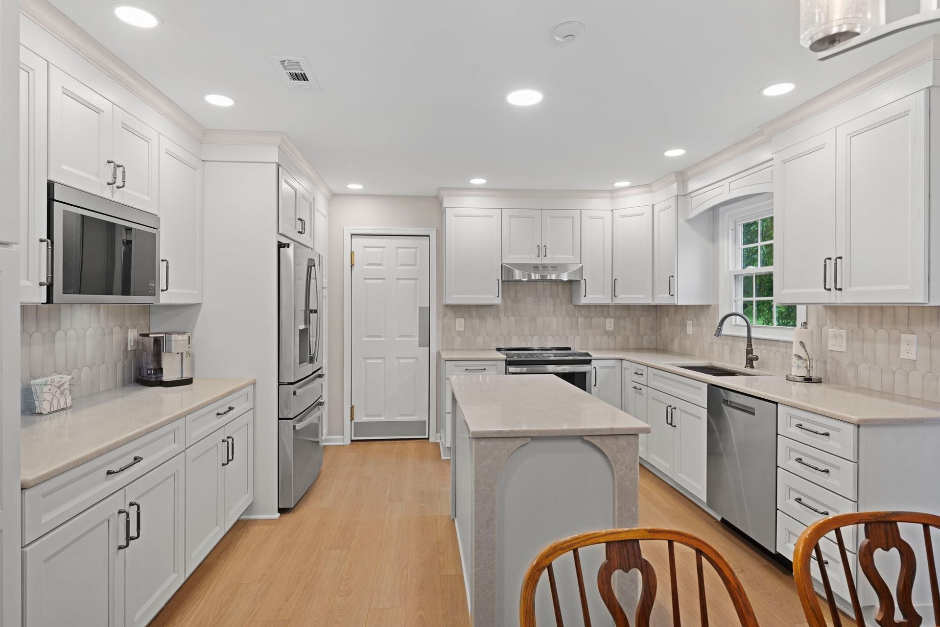 Bright white kitchen with island, stainless appliances, and light wood floors in Bucks County PA