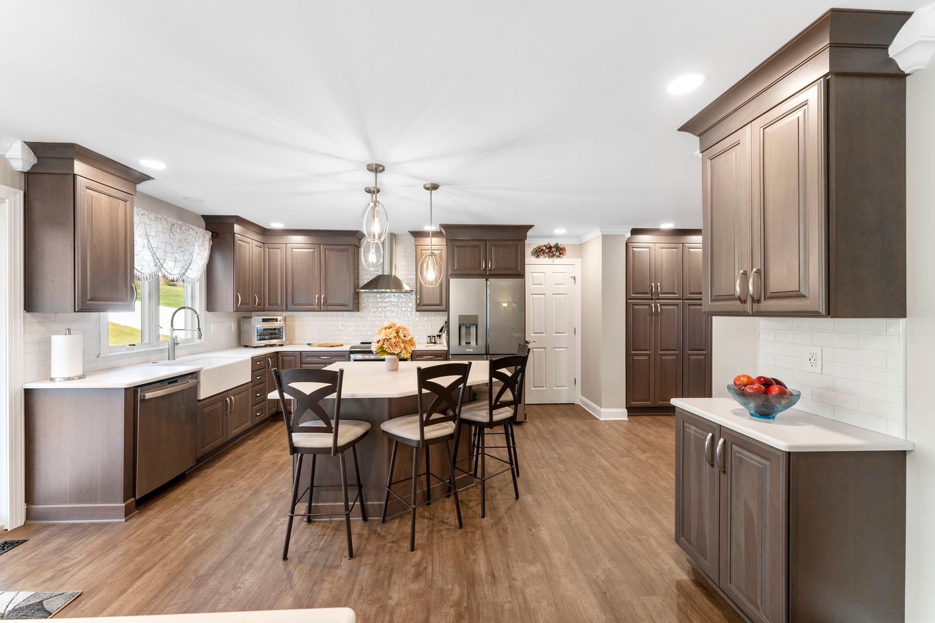 Bright kitchen with dark wood cabinets, island seating, and hardwood floors In Bucks Country PA