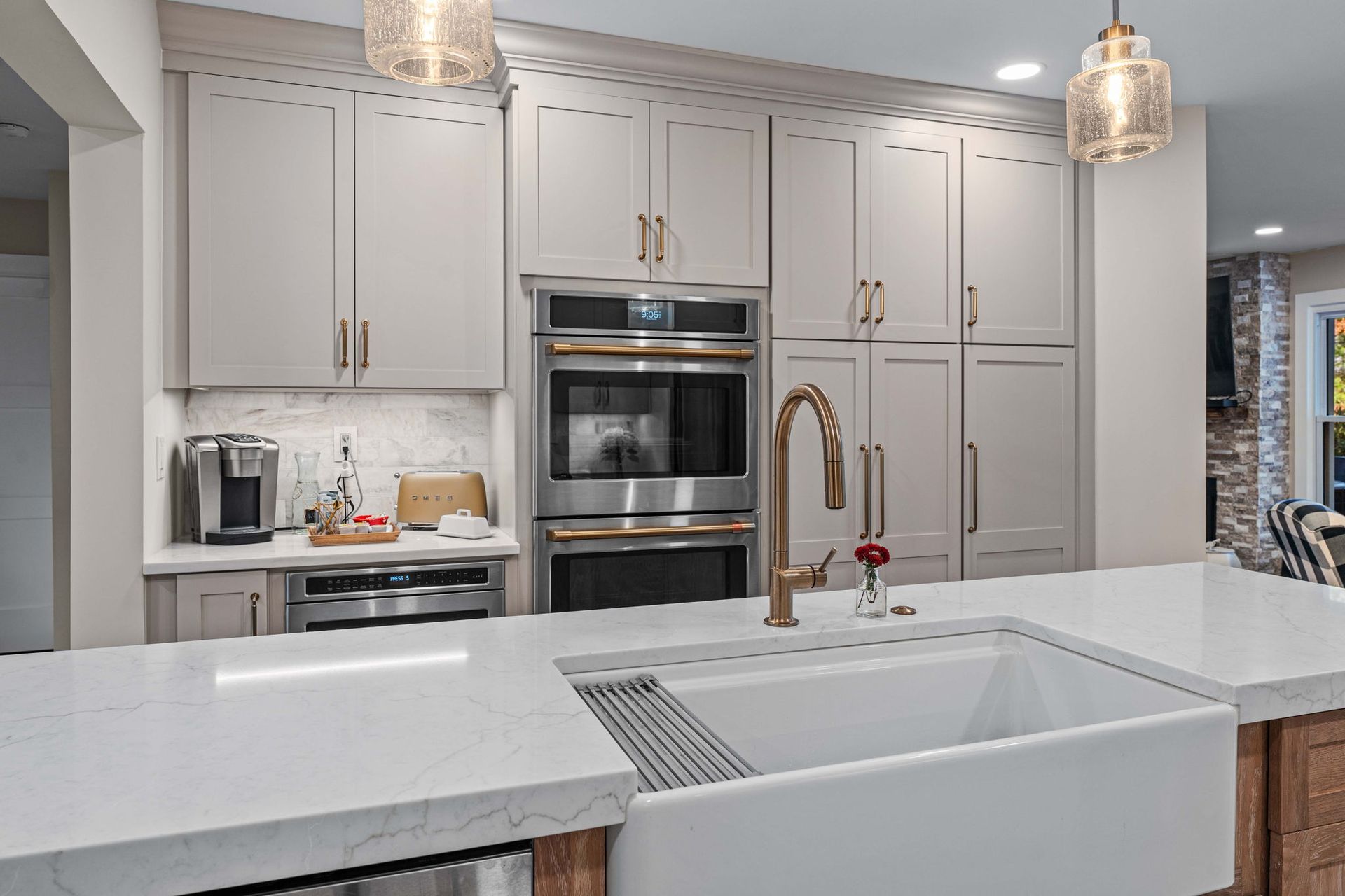 Bright modern kitchen with white cabinets, island sink, and stainless steel appliances in Bucks County PA