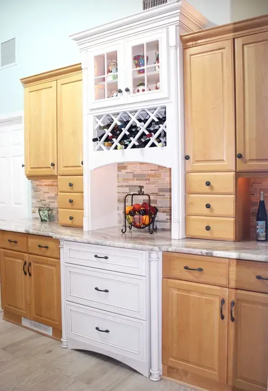 White kitchen hutch with wine rack and fruit bowl between wood cabinets and drawers in Washington 