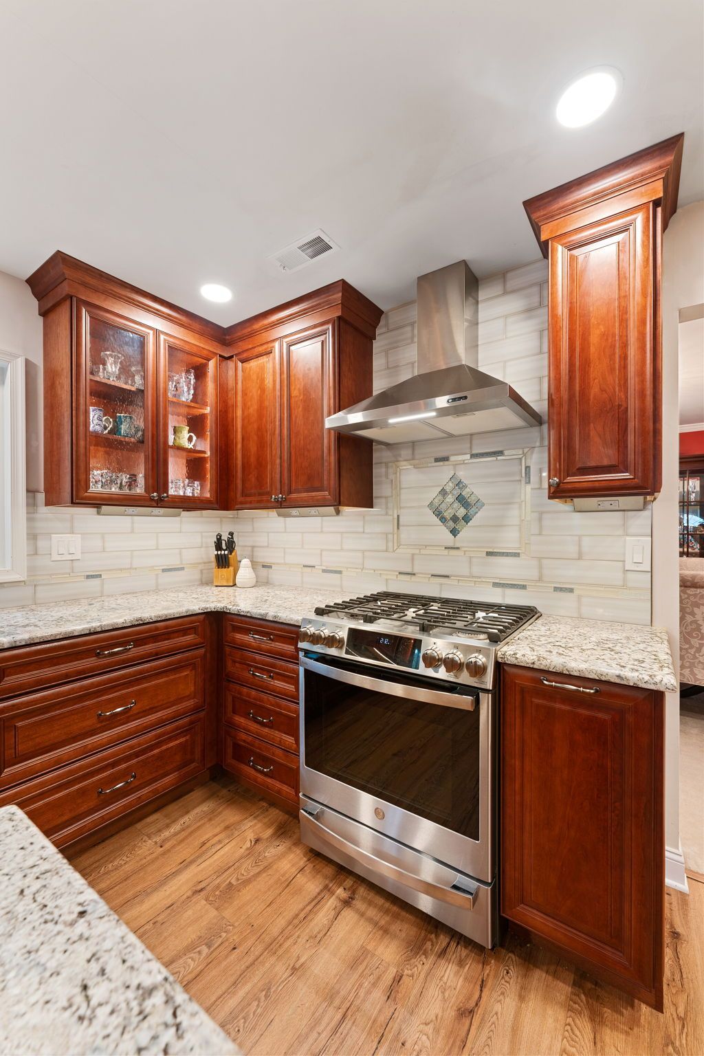 Modern kitchen with cherry wood cabinets, stainless steel stove, and granite countertops  In Bucks County PA