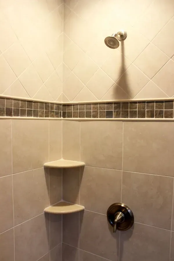 Tiled shower stall with corner shelves and chrome shower fixtures In Bucks County PA
