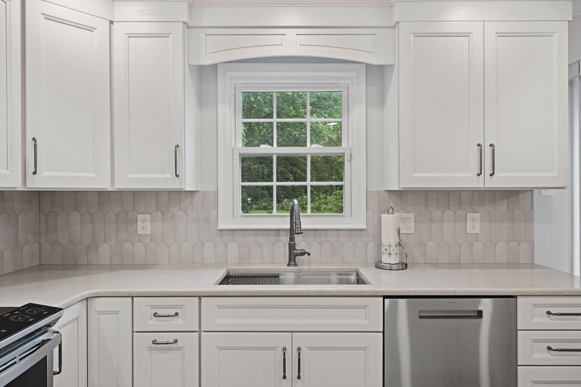Bright white kitchen with cabinets, marble countertops, and a window above the sink in Bucks County PA