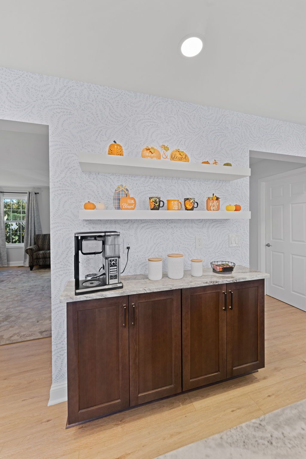 Wooden buffet cabinet with coffee maker and decor on shelves in a bright hallway  In Bucks County PA