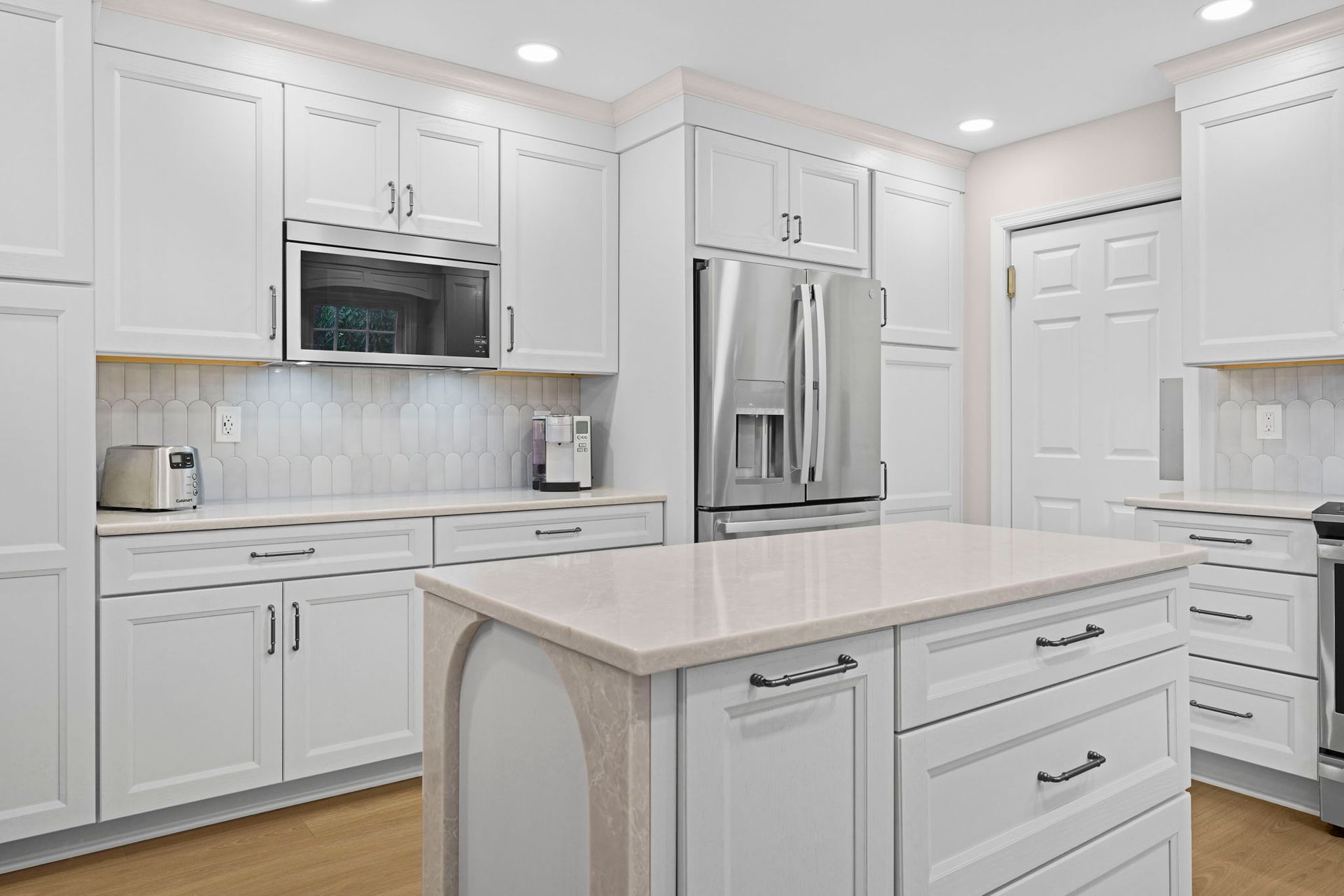 Bright white modern kitchen with stainless steel appliances and a central island In Bucks Country PA