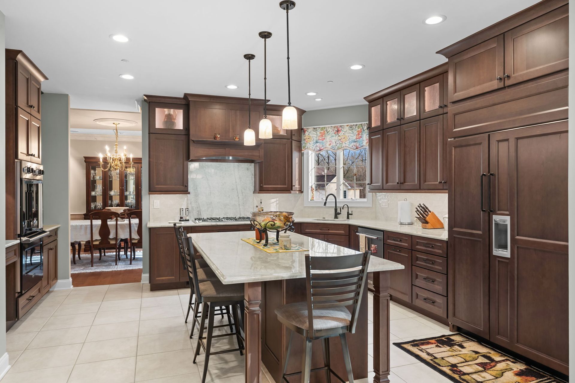Modern kitchen with dark wood cabinets, central island, barstools, and stainless steel appliances In Bucks Country PA