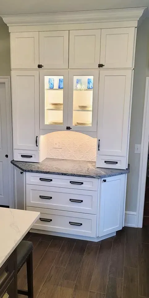 White built-in cabinet with marble countertop, drawers, and mirrored display shelves in a room In Bucks County PA