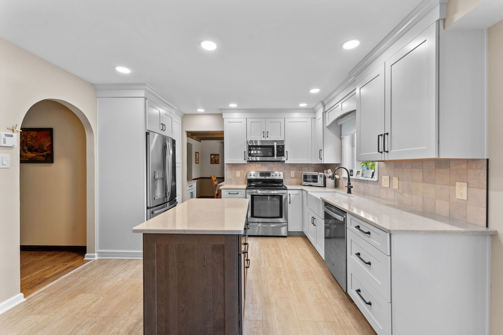 Bright modern kitchen with white cabinets, stainless appliances, and a central island  In Bucks County PA