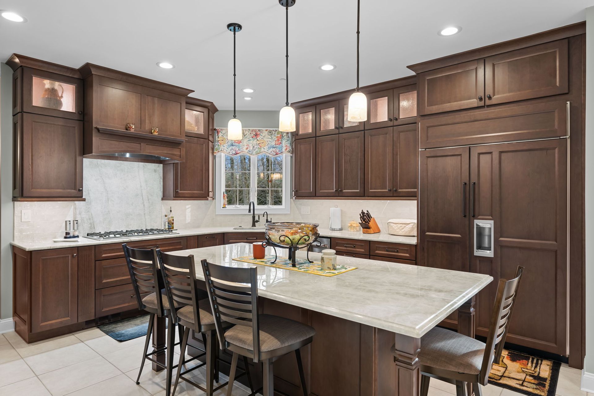 Modern kitchen with dark wood cabinets, stainless fridge, island, and pendant lights In Bucks Country PA