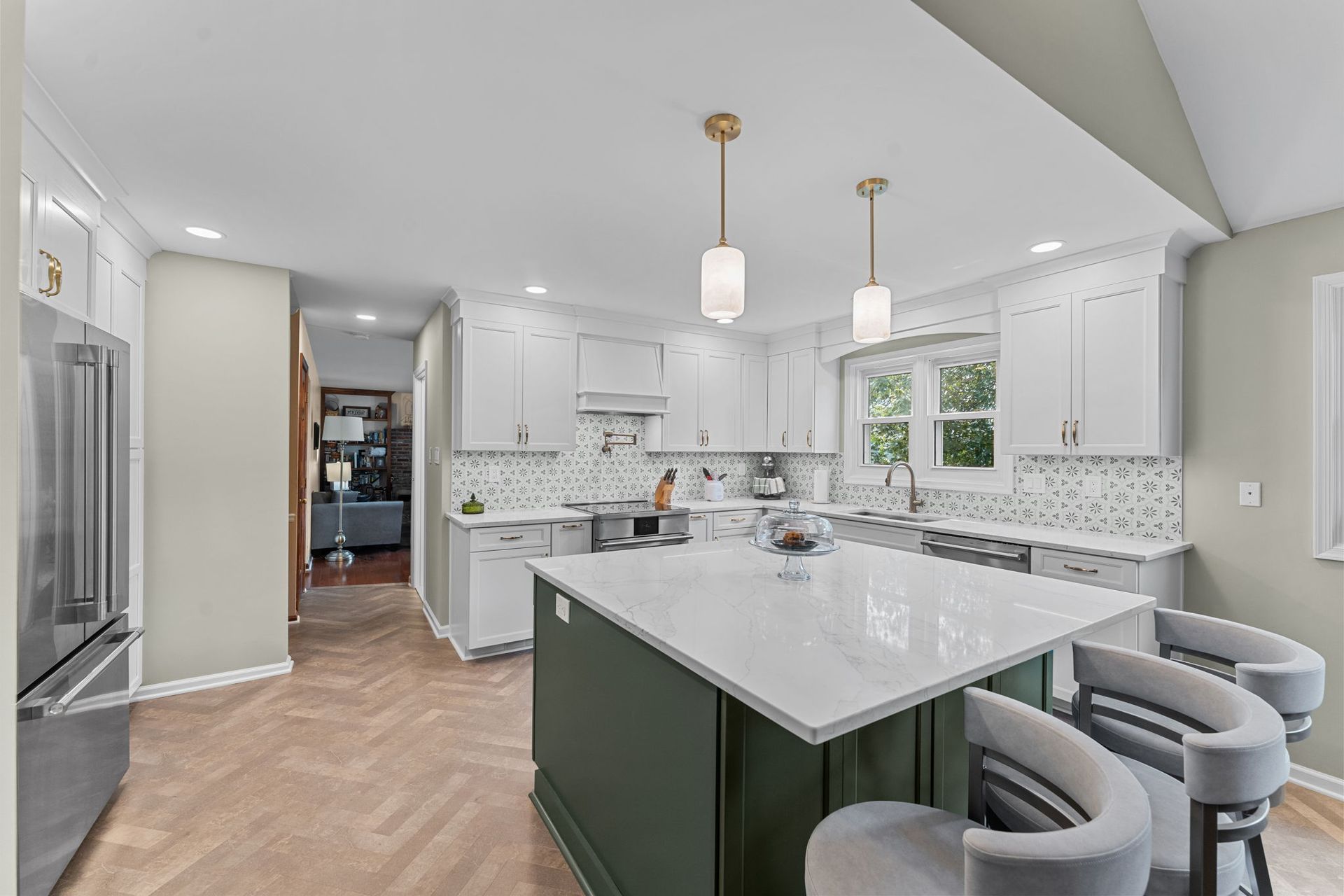 Bright modern kitchen with white cabinets, marble island, and gray barstools In Bucks County PA