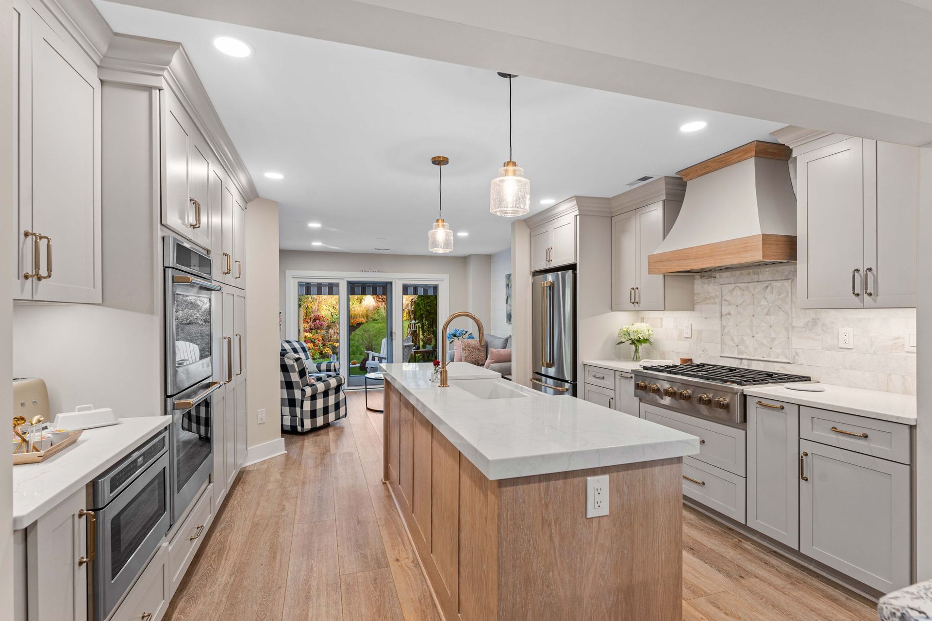 Bright modern kitchen with white cabinets, wood island, stainless appliances, and a view to the backyard in Bucks County PA
