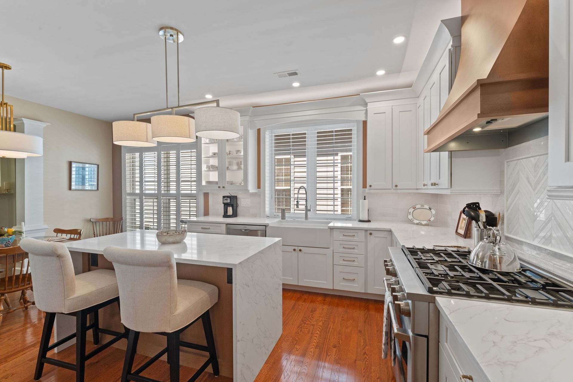 Bright modern kitchen with white cabinets, island seating, and stainless steel appliances In Bucks County PA