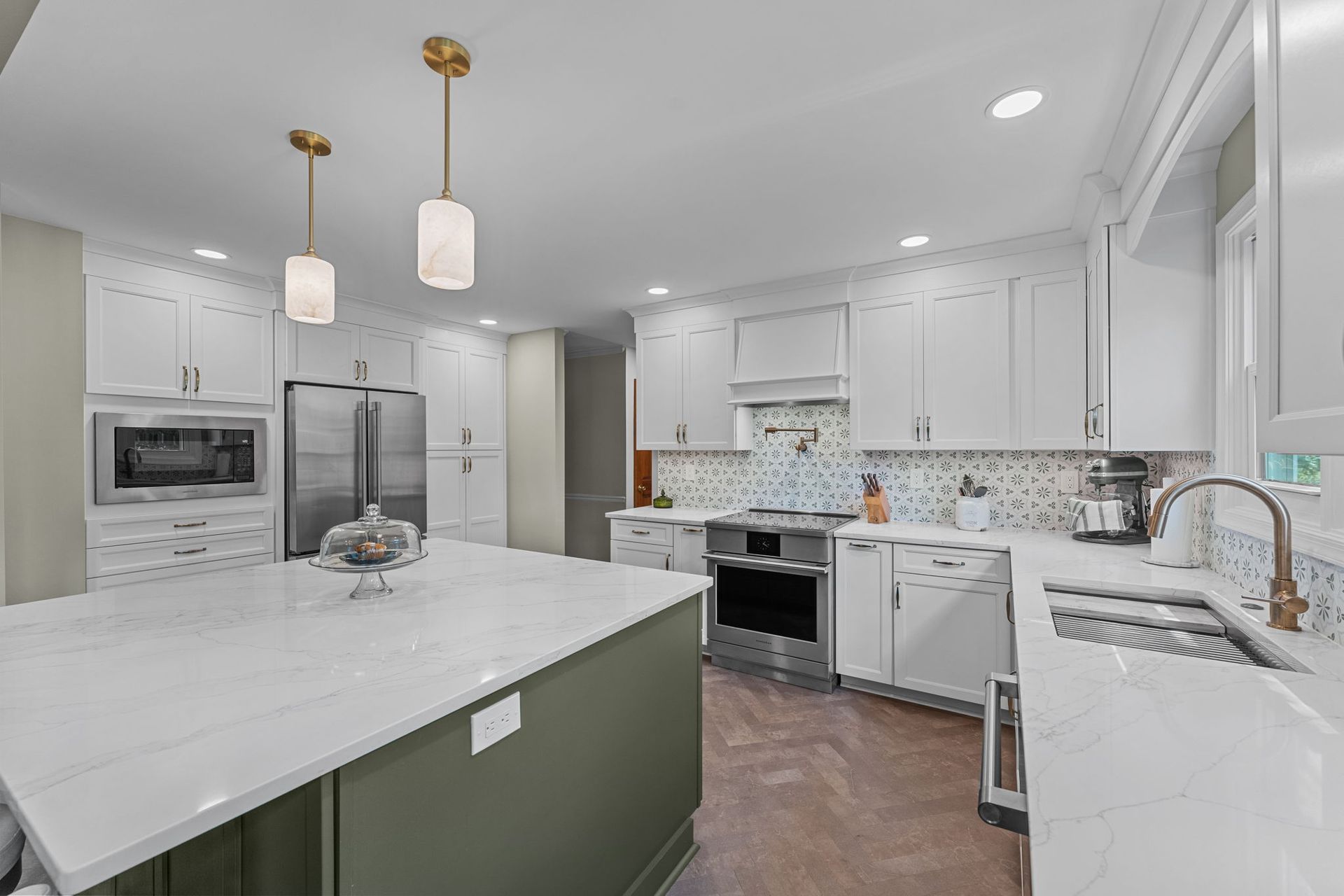 Bright white modern kitchen with island, stainless appliances, and pendant lights In Bucks County PA