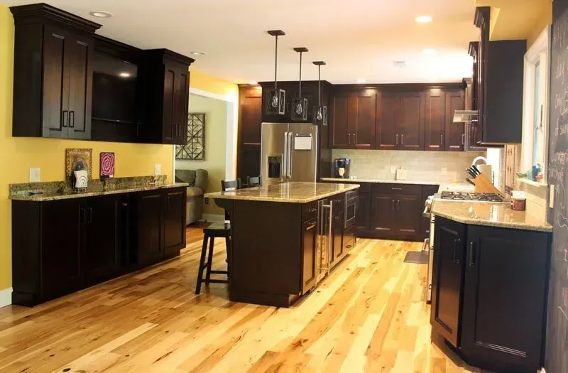 Modern kitchen with dark cabinets, black island, and hardwood floors In Bucks County PA
