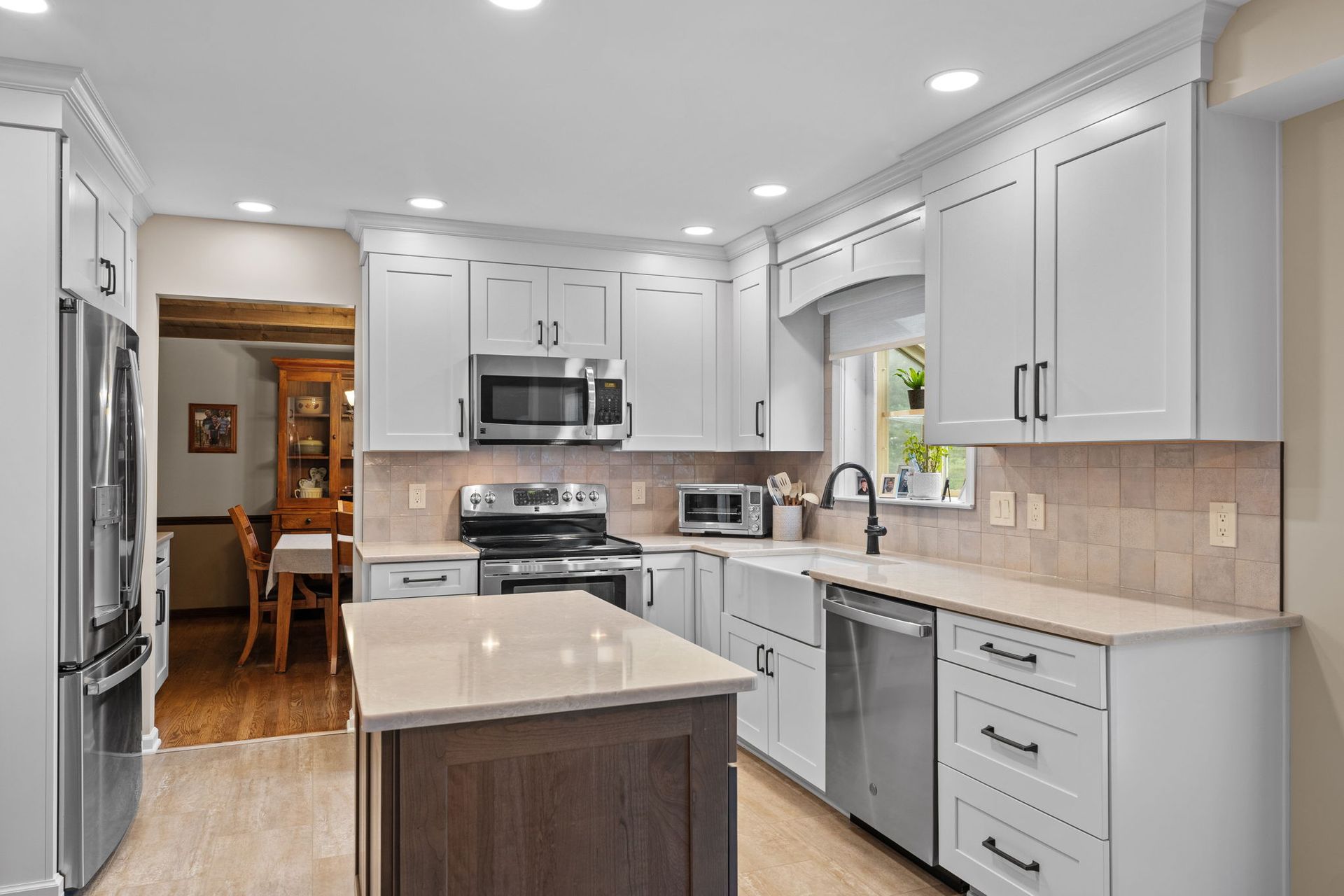 Bright modern kitchen with white cabinets, stainless appliances, and a small island  In Bucks County PA