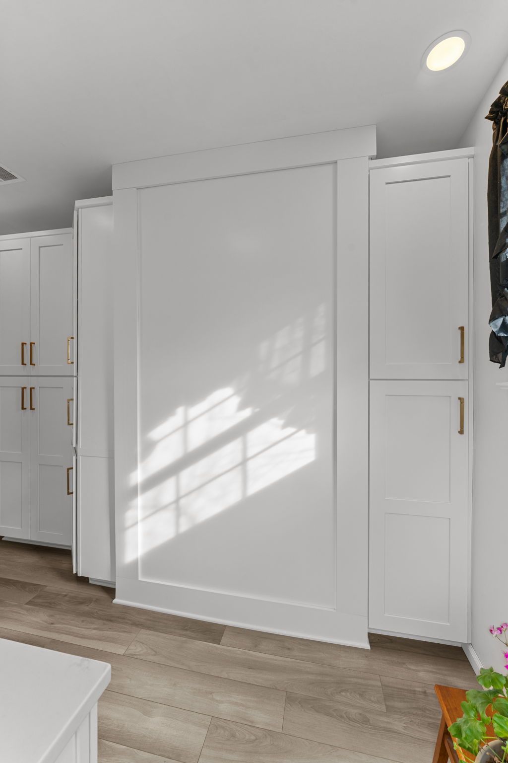 White built-in cabinets and a large paneled closet door in a bright kitchen or hallway In Bucks County PA