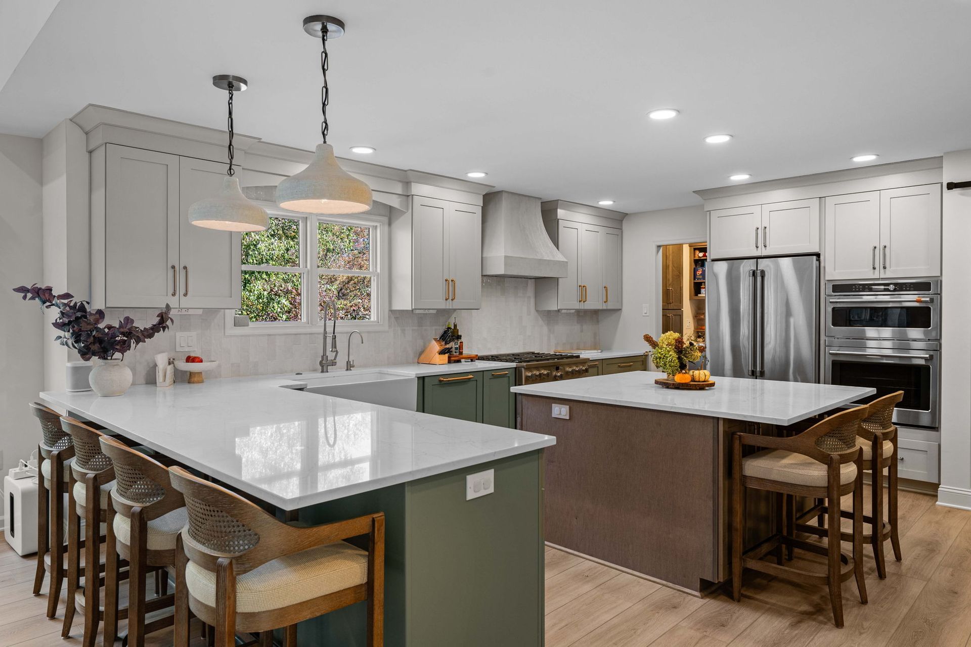 Bright modern kitchen with white island, dark wood island, stainless appliances, and pendant lights in Bucks County PA