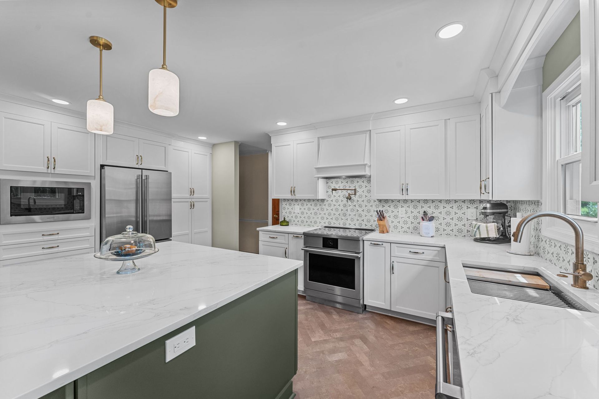 Bright white modern kitchen with marble island, stainless appliances, and pendant lights In Bucks County PA