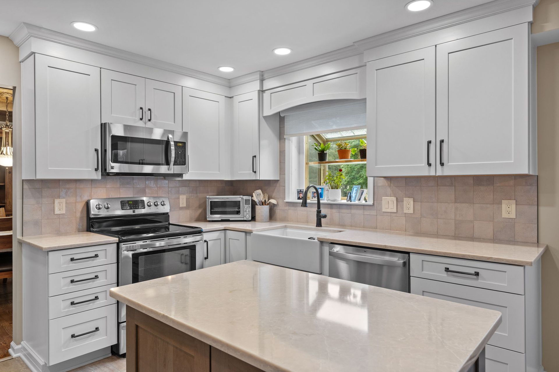 Bright modern kitchen with white cabinets, stainless appliances, and a large island  In Bucks County PA