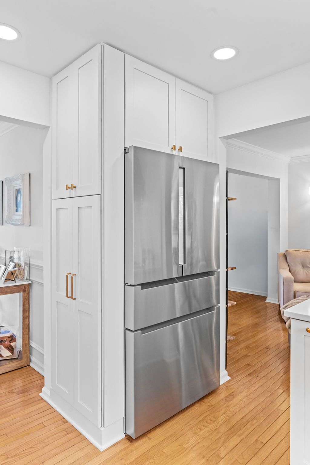 Modern kitchen corner with a stainless steel refrigerator and tall white cabinets on a wood floor In Bucks Country PA