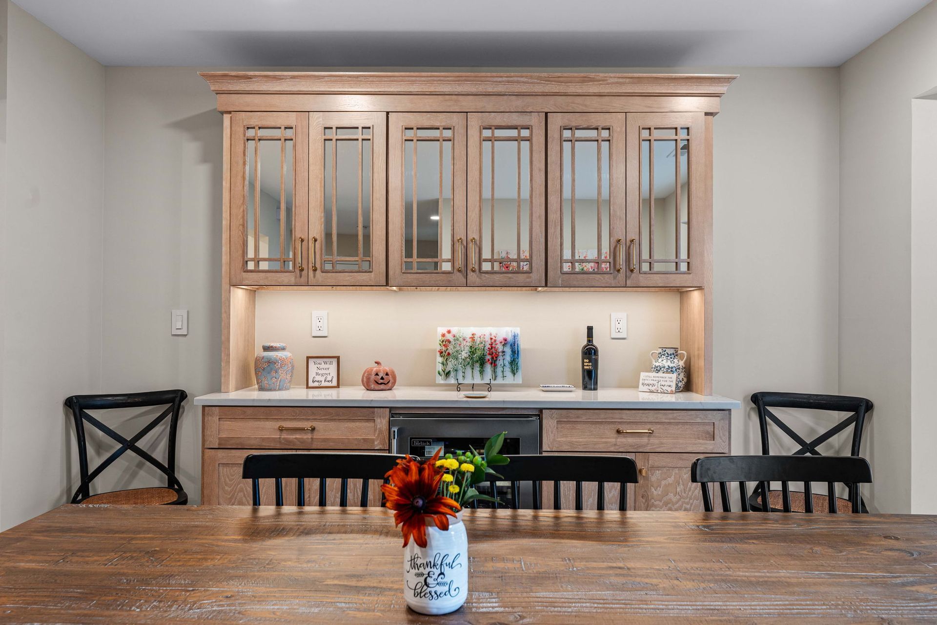 Dining room with built-in cabinets, wood table, and chairs; sunflower centerpiece in foreground in Bucks County PA