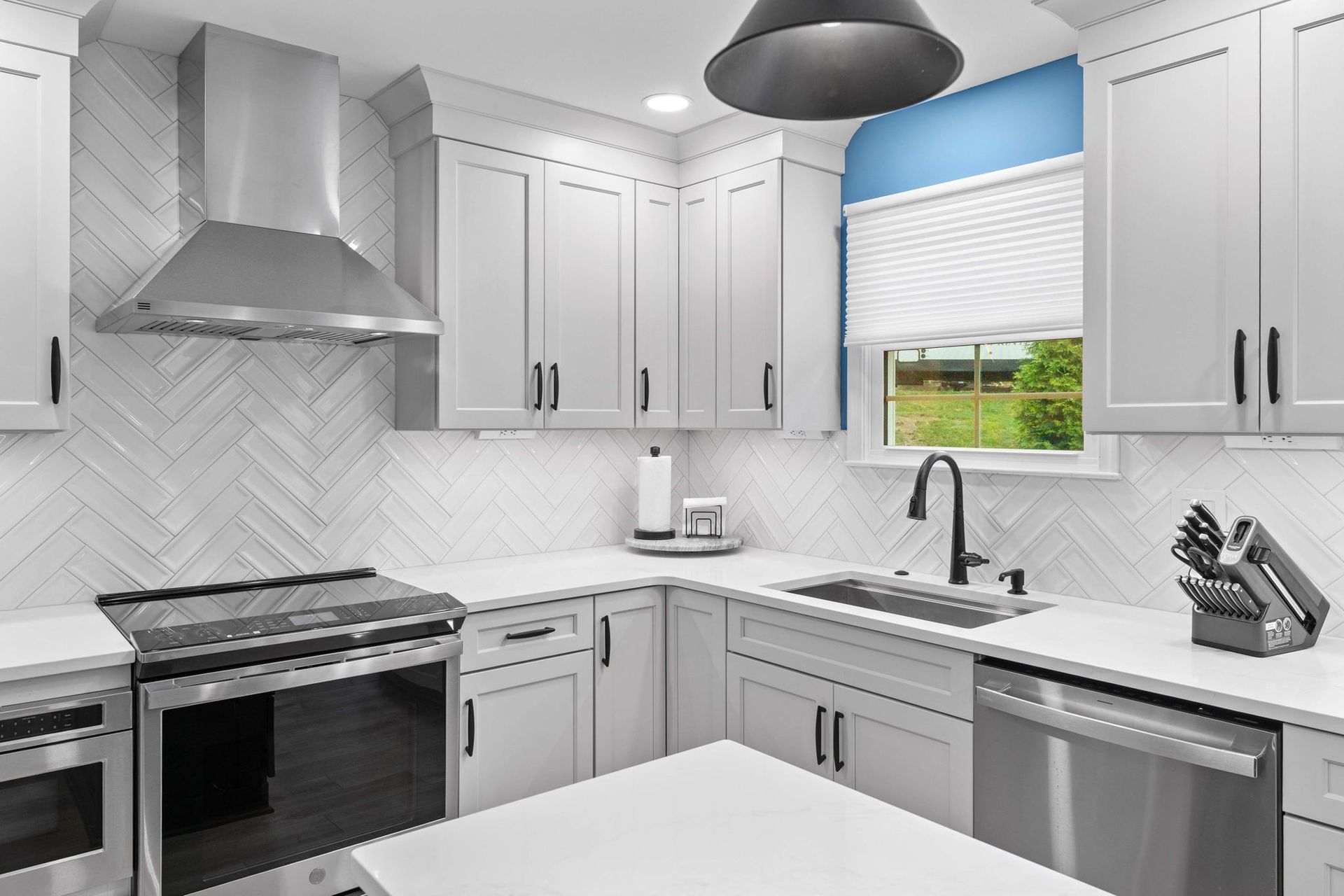 Bright modern kitchen with white cabinets, stainless appliances, and a window over the sink in Bucks County PA