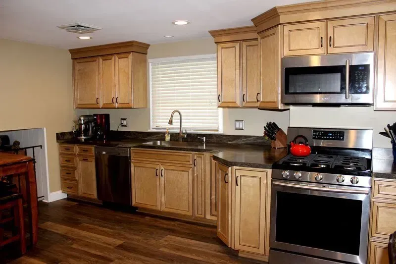 Modern kitchen with wood cabinets, stainless steel appliances, and a window above the sink  In Bucks County PA