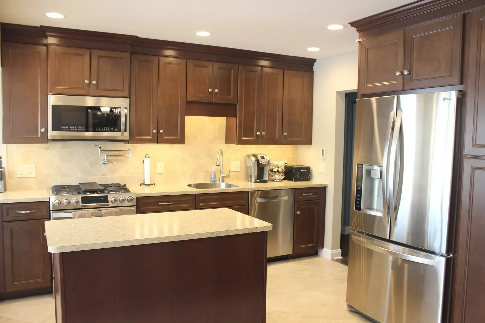 Modern kitchen with dark wood cabinets, stainless steel appliances, and a center island countertop  In Bucks County PA