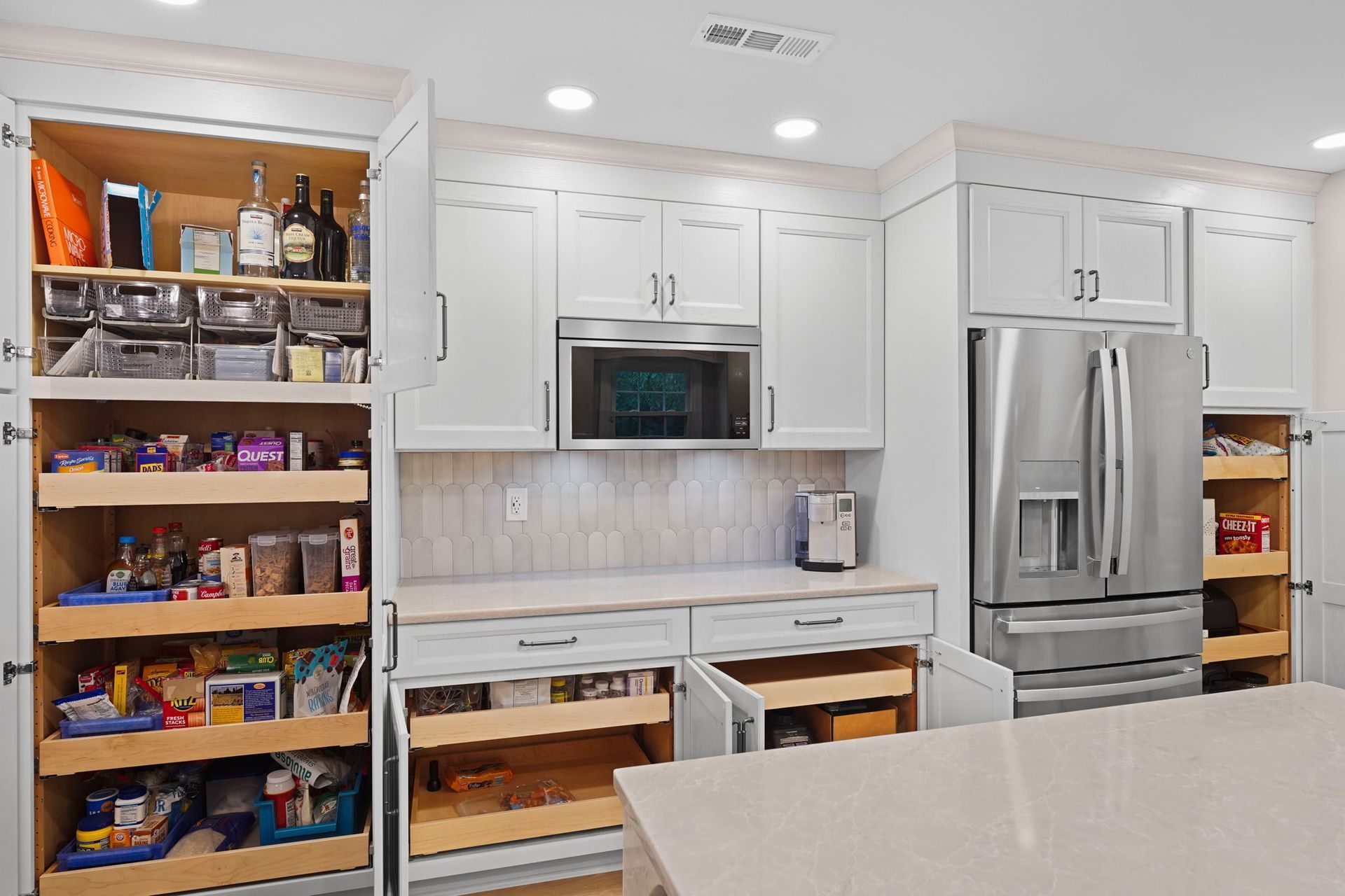 Modern kitchen with white cabinets, stainless steel fridge, and open pantry shelves in a bright interior in Bucks County PA