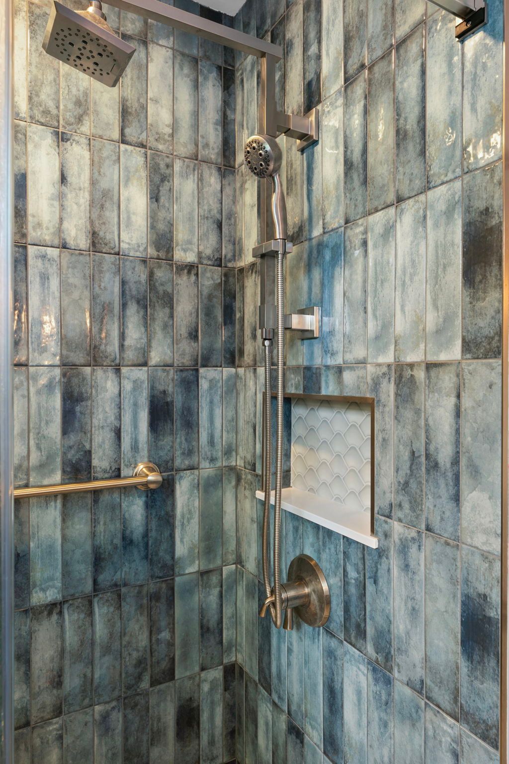 Blue-tiled shower with multiple showerheads and a built-in shelf In Bucks County PA
