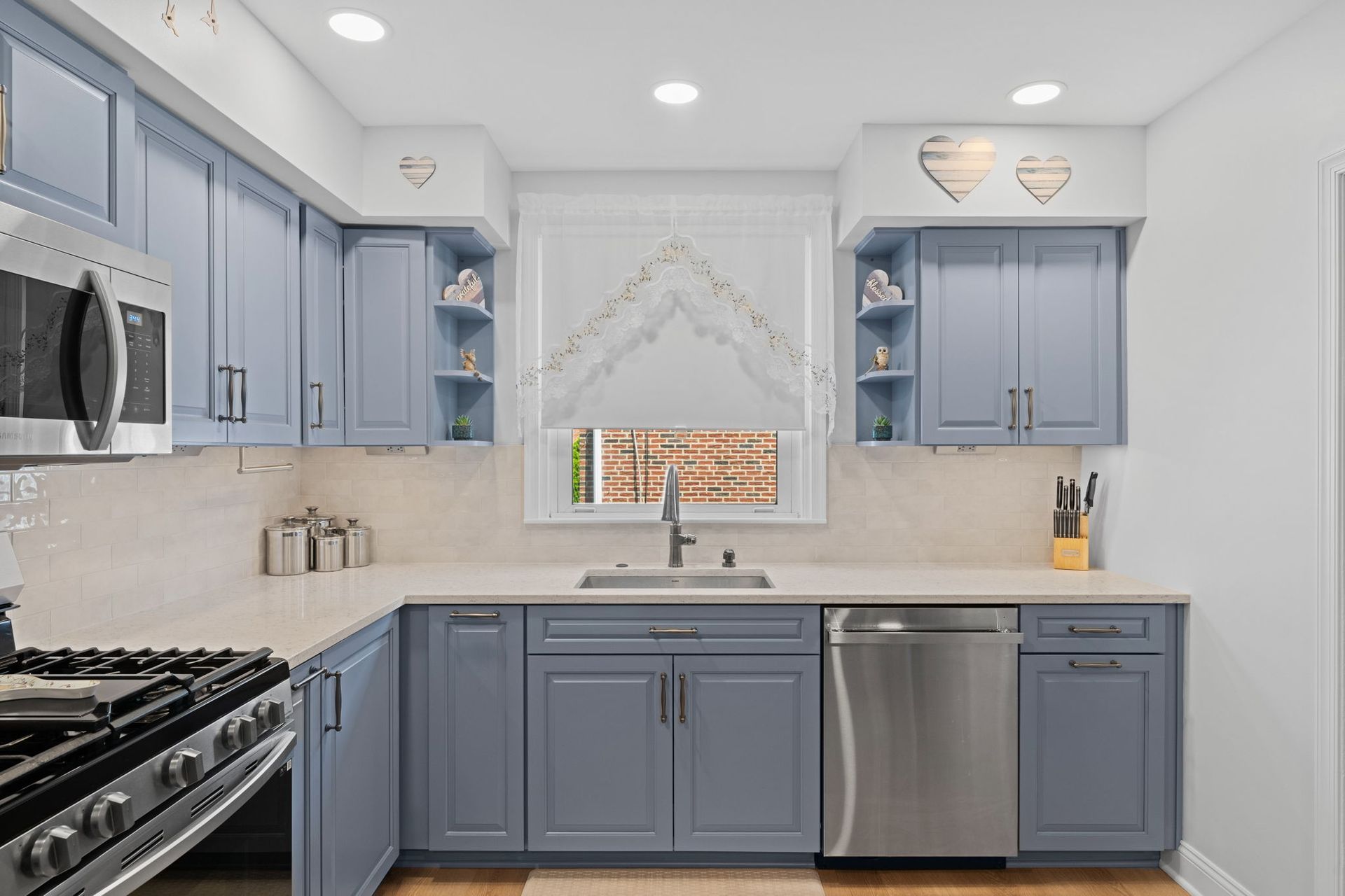 Modern kitchen with blue-gray cabinets, stainless appliances, and a window over the sink In Bucks County PA
