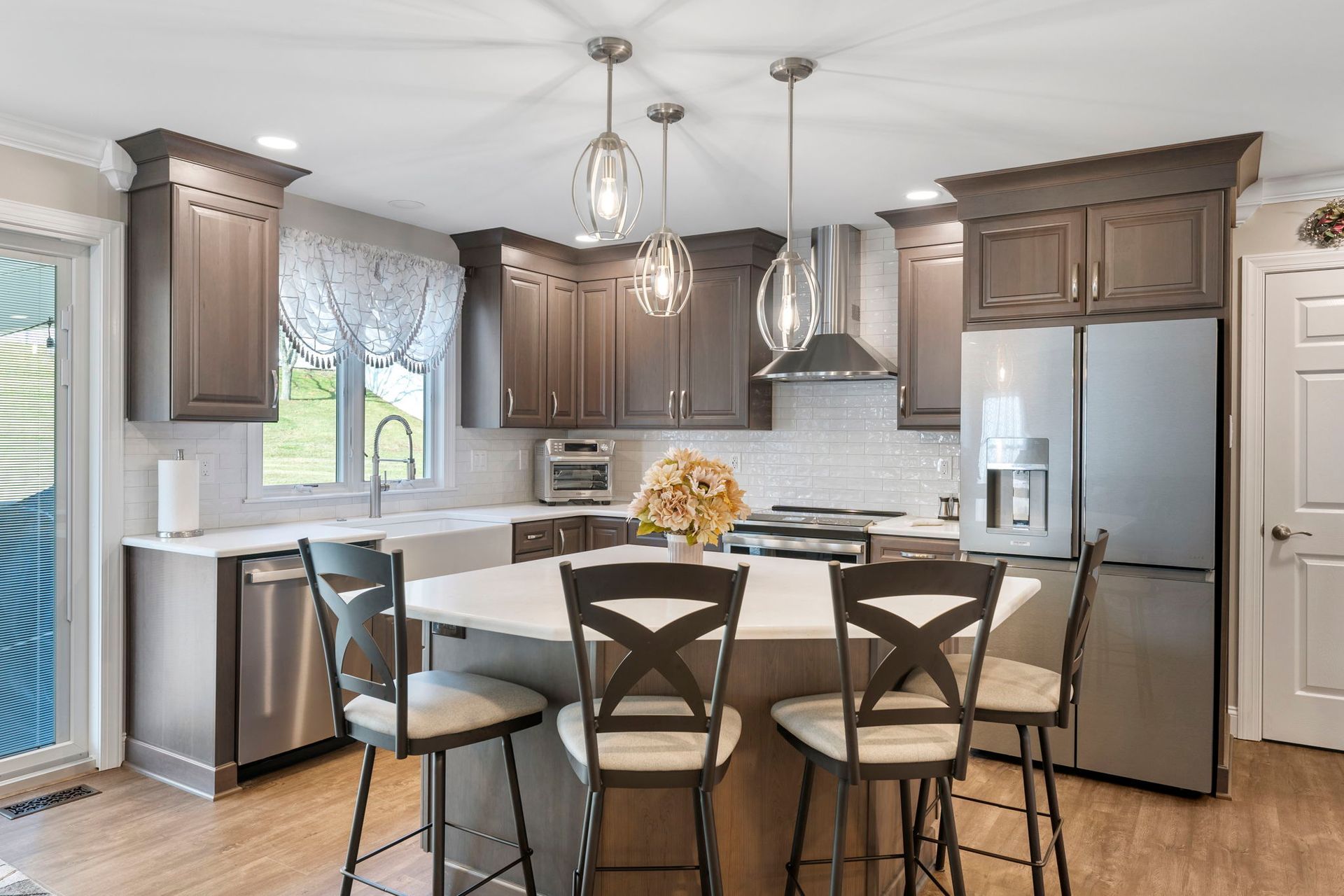 Modern kitchen with stainless appliances, dark wood cabinets, and a center island with bar stools In Bucks Country PA