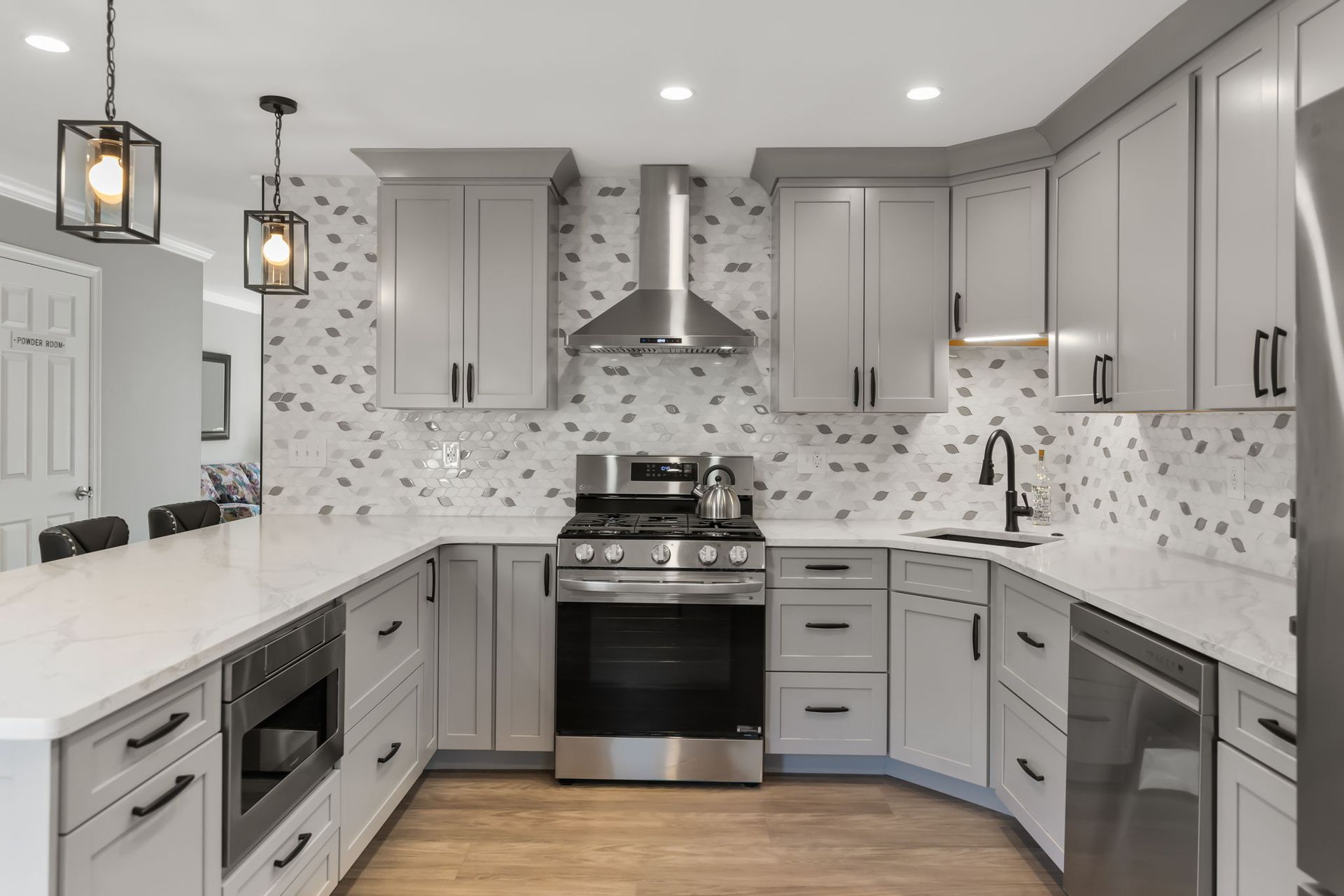 Modern gray-and-white kitchen with marble backsplash, stainless appliances, and pendant lights In Northeast Philadelphia