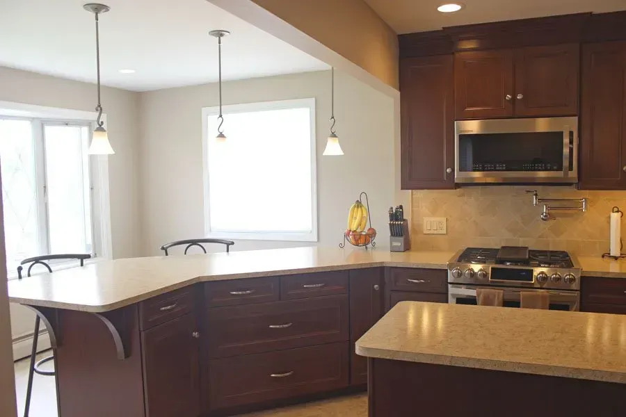 Modern kitchen with dark wood cabinets, granite countertops, island, and stainless steel appliances  In Bucks County PA