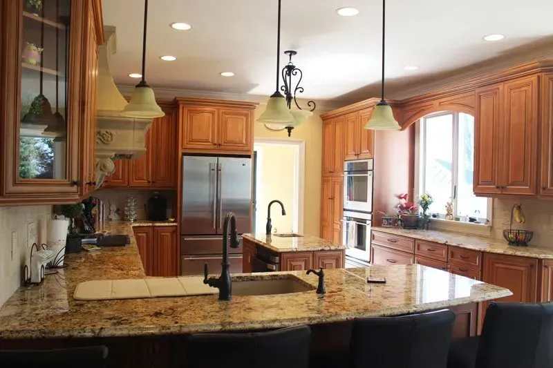 Spacious kitchen with granite island, wood cabinets, stainless steel appliances, and pendant lights  In Bucks County PA