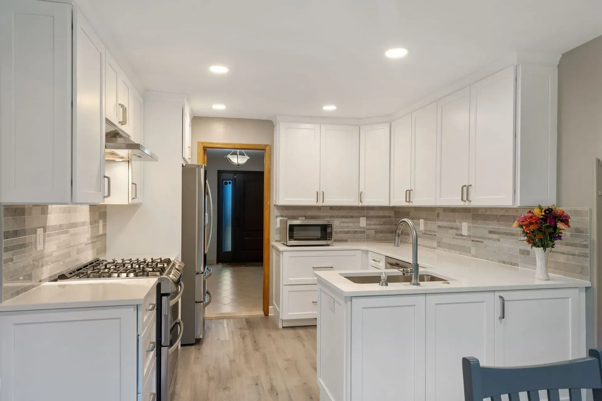 Bright white kitchen with island, stainless appliances, and recessed lighting in  Bucks County PA