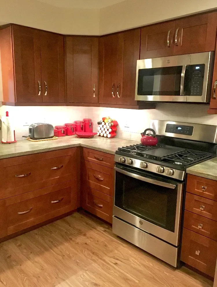 Modern kitchen with wooden cabinets, stainless steel stove and microwave, and light countertops  In Bucks County PA