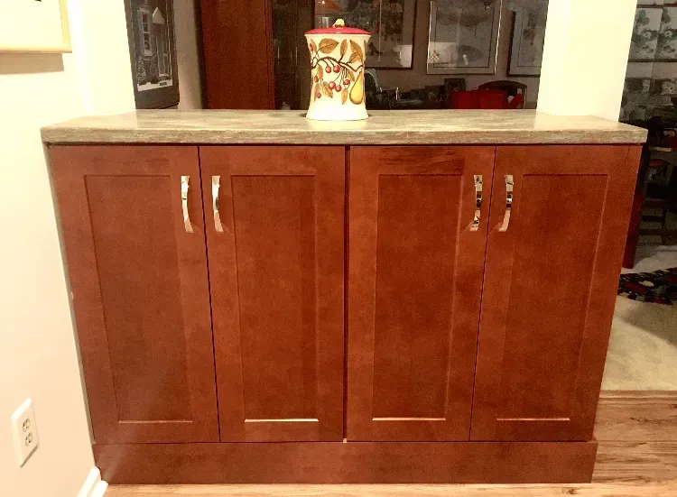 Wooden kitchen cabinet with silver handles and a decorative container on top  In Bucks County PA