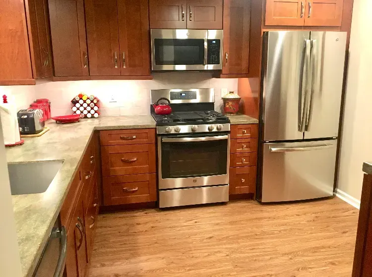 Modern kitchen with stainless steel appliances, wooden cabinets, and light wood flooring In Bucks Country PA