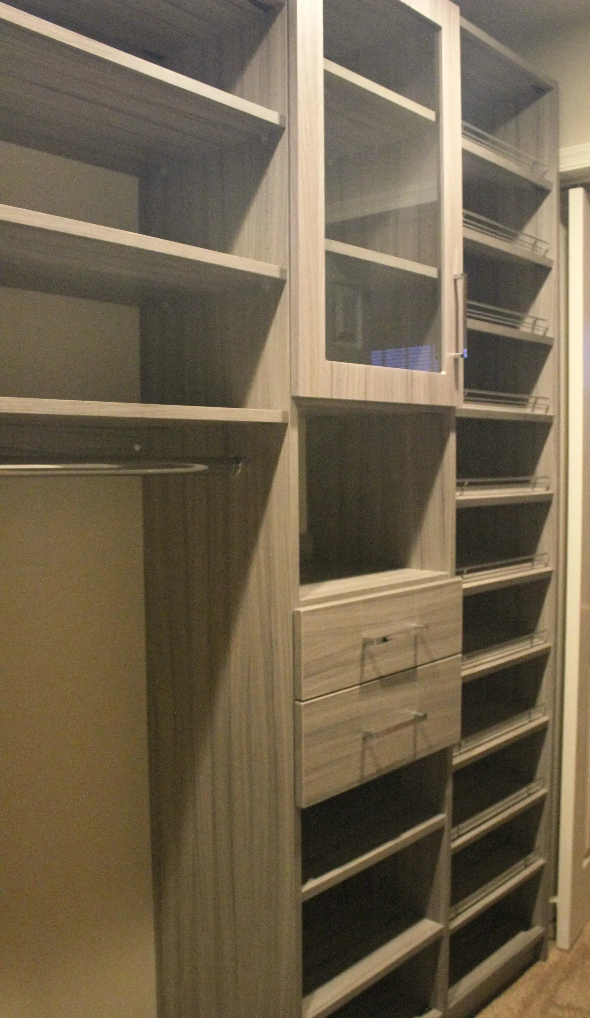 Built-in closet with open shelving, drawers, hanging space, and a tall shoe rack in a beige room In Bucks Country PA