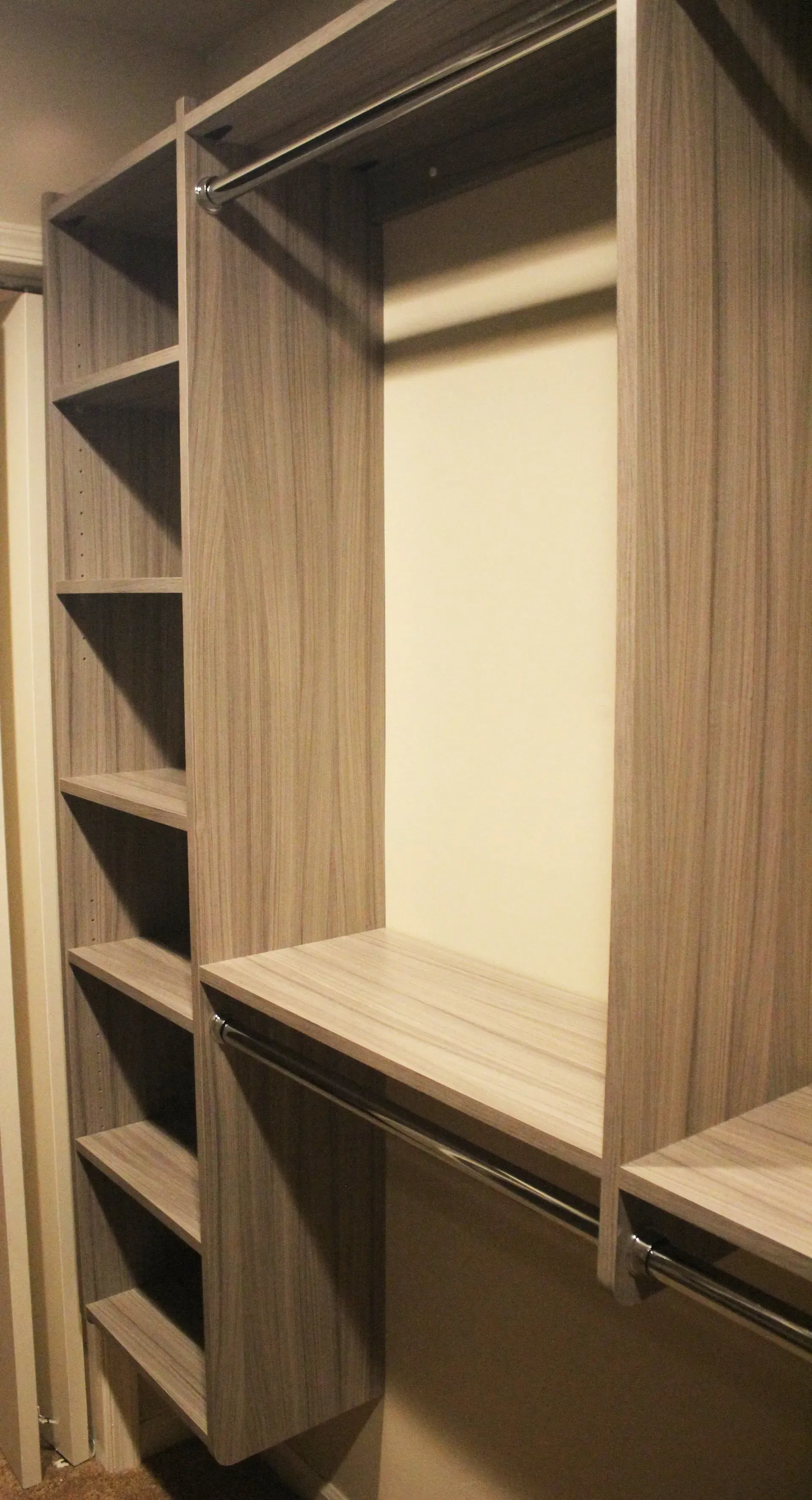 Built-in wooden closet with open shelves and a hanging section, empty interior In Bucks Country PA